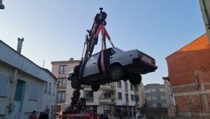 Satın aldığı klasik otomobili bulunduğu bahçeden vinç yardımıyla çıkardı